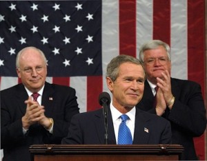 President George W. Bush pauses for applause during his State of the Union Address on Jan. 28, 2003, when he made a fraudulent case for invading Iraq. Seated behind him are Vice President Dick Cheney and House Speaker Dennis Hastert.