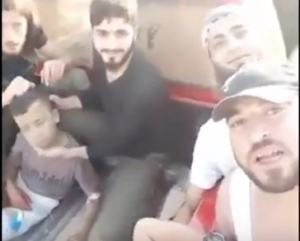 U.S.-backed Syrian "moderate" rebels smile as they prepare to behead a 12-year-old boy (left), whose severed head is held aloft triumphantly in a later part of the video. [Screenshot from the YouTube video]