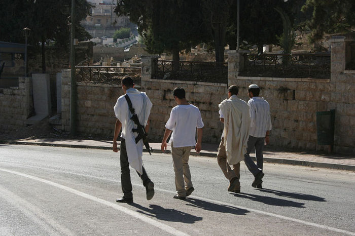 Settlers taking a walk on Shuhada Street in Hebron, 2010. (Stella via Wikimedia)