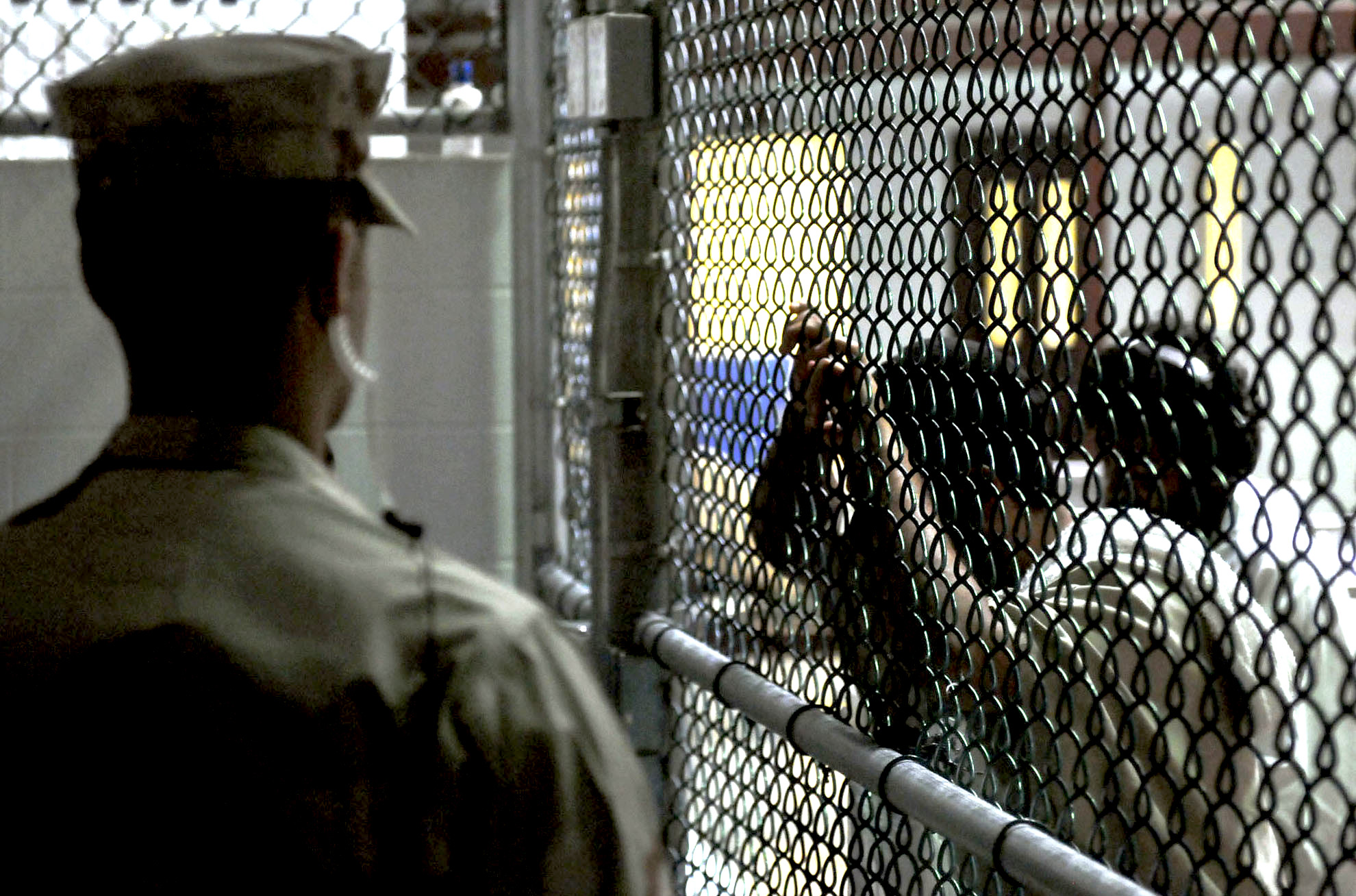 A US soldier watches over detainees in a cell block in the military prison at US Naval Station Guantanamo Bay, Cuba, March 30, 2010. Photo: US Navy/Joshua Nistas